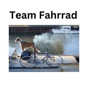 Hund steht neben einem Fahrrad am Wasser